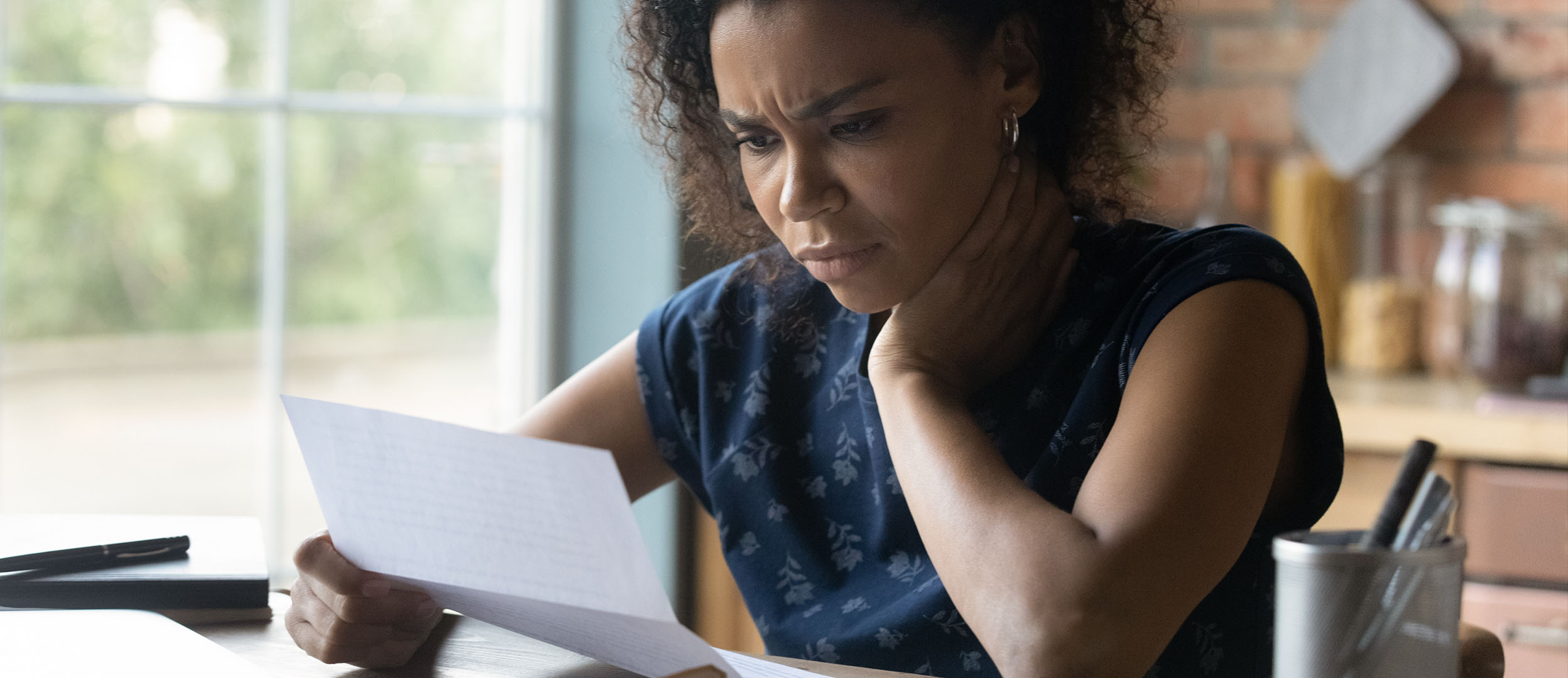 Woman reading paper looks stressed