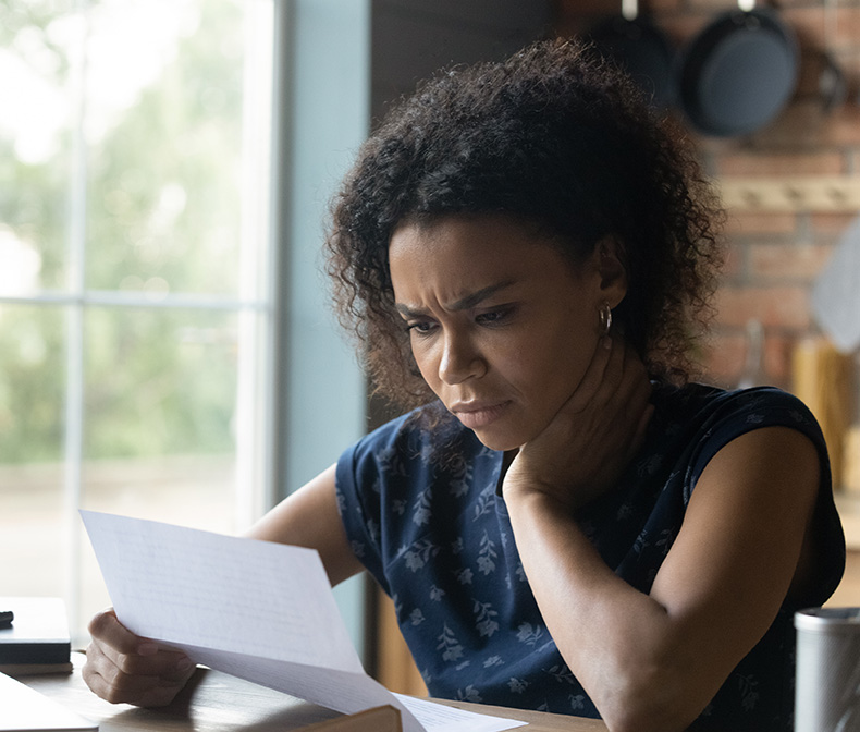 Woman reading paper looks stressed